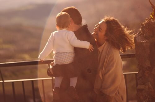 man in white dress shirt carrying girl in black dress