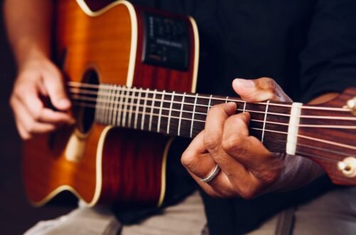 photo of person playing acoustic guitar